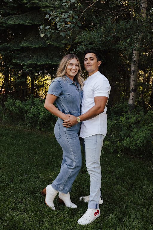Akylah and Chad standing together among the pines