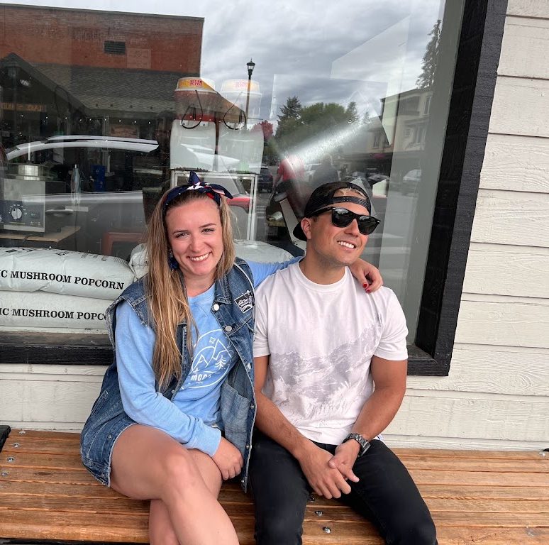 Akylah and Chad on a bench outside a shop window in McCall