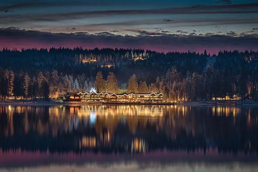 Shore Lodge lit up at night, reflected in Payette Lake